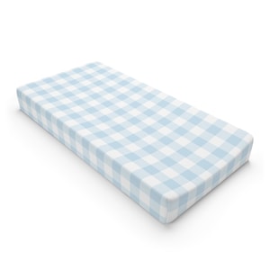 May include: A light blue and white checkered crib mattress pad.
