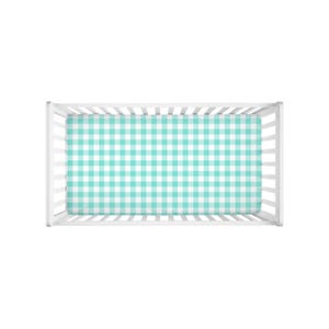 May include: A white crib with a turquoise and white gingham patterned fitted sheet. The crib is rectangular with vertical slats on the sides and a solid headboard and footboard. The sheet covers the entire mattress.