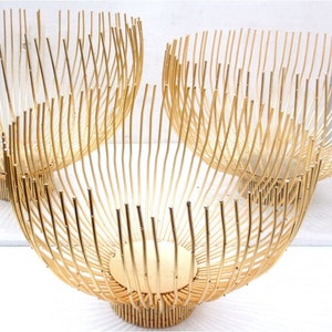 May include: Three gold wire bowls of varying sizes. The bowls are made of thin, interwoven wires that create a delicate and airy design.