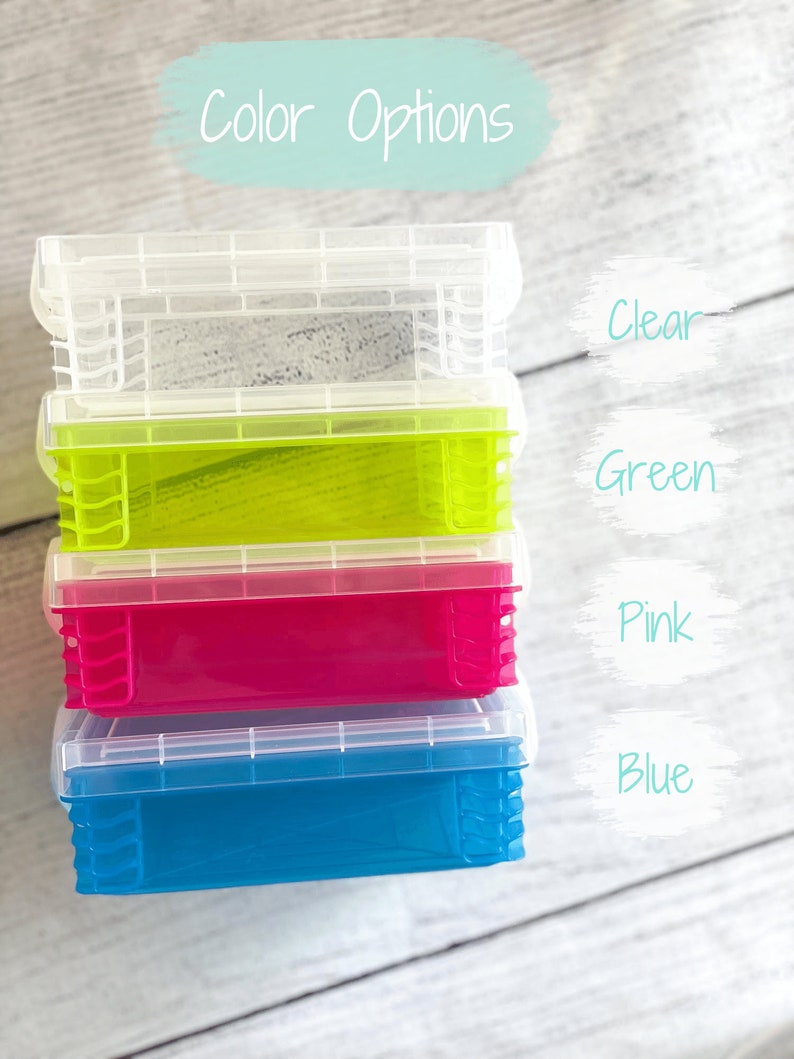Op de afbeelding: Stapel van vier doorzichtige plastic opbergcontainers met deksels. De containers zijn in de kleuren helder, groen, roze en blauw. De tekst "Color Options" staat boven de containers.