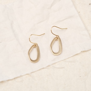 Peut inclure: Une paire de boucles d'oreilles dorées avec une forme organique unique. Les boucles d'oreilles sont en métal lisse et ont un design simple et minimaliste.