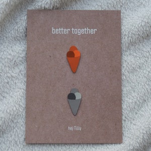 May include: A brown card with the text "better together" printed in white. Two ice cream cones are glued to the card, one orange and one gray.