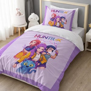 May include: A lavender and white single bed set featuring an animated illustration of three characters and a blue cat. The word "HUNTR" is printed on the pillowcase and duvet cover. The bed set is on a white bed frame.