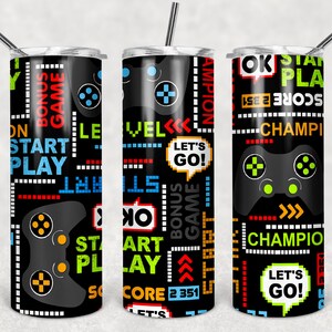 May include: Three black and white stainless steel tumblers with a gamer theme. The tumblers feature a black background with colorful text and graphics, including a game controller, the words "Start Play", "Let's Go!" and "Champion".