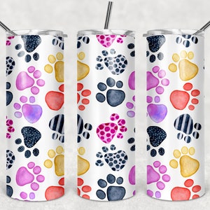 May include: Three stainless steel tumblers with a white background and a colorful paw print pattern. The paw prints are in shades of pink, red, yellow, blue, and purple.
