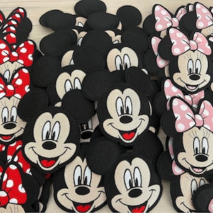 May include: A collection of black and white embroidered iron-on patches featuring Mickey Mouse and Minnie Mouse. The patches have different expressions and poses. Some patches have red and white polka dot bows, while others have pink and white polka dot bows.