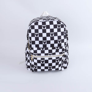 May include: Black and white checkered backpack with a black Mickey Mouse silhouette pattern. The backpack has a gold zipper.