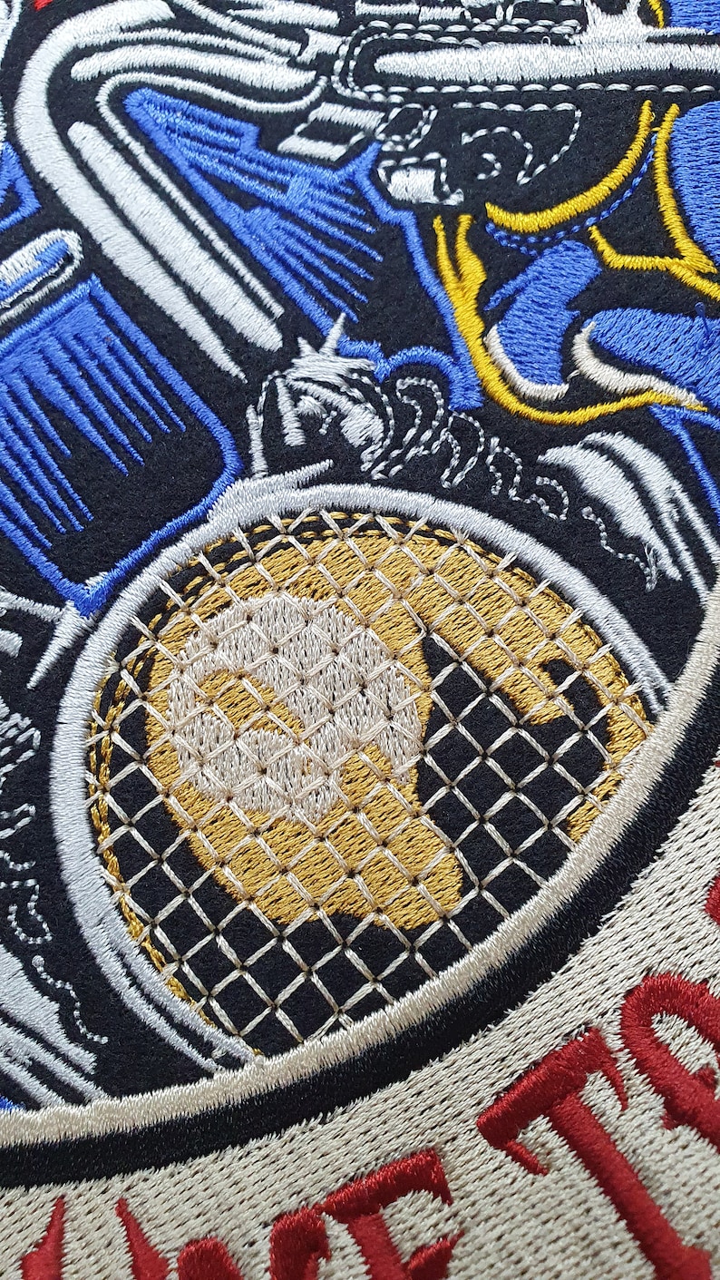 May include: Embroidered patch with a tennis racket design. The patch features a gold and white racket head with a black and white handle. Blue, white, and yellow embroidered details surround the racket, set against a black background.