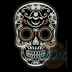 May include: Embroidered skull design with intricate floral and ornamental details in white, orange, and black. The skull features large eye sockets, a detailed jawline, and decorative patterns, perfect for Day of the Dead themes.