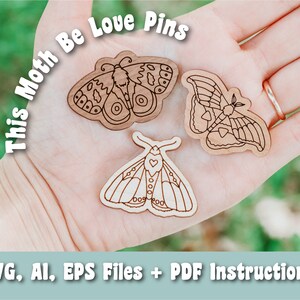 May include: Three wooden moth pins with a heart design. The text "This Moth Be Love Pins" is written in white letters on a green background.
