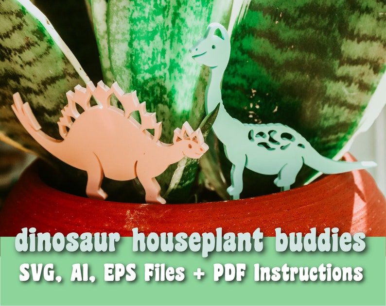 May include: Two pink and blue dinosaur houseplant buddies made of acrylic. The dinosaurs are standing in a red pot with a green plant. The image includes the text "dinosaur houseplant buddies" and "SVG, AI, EPS Files + PDF Instructions".