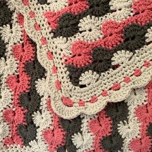 A handcrafted crocheted Catherine Wheel stitch baby girl blanket!  Done in Lion Brand “Feels Like Butta” yarn!  Incredibly soft and warm.
