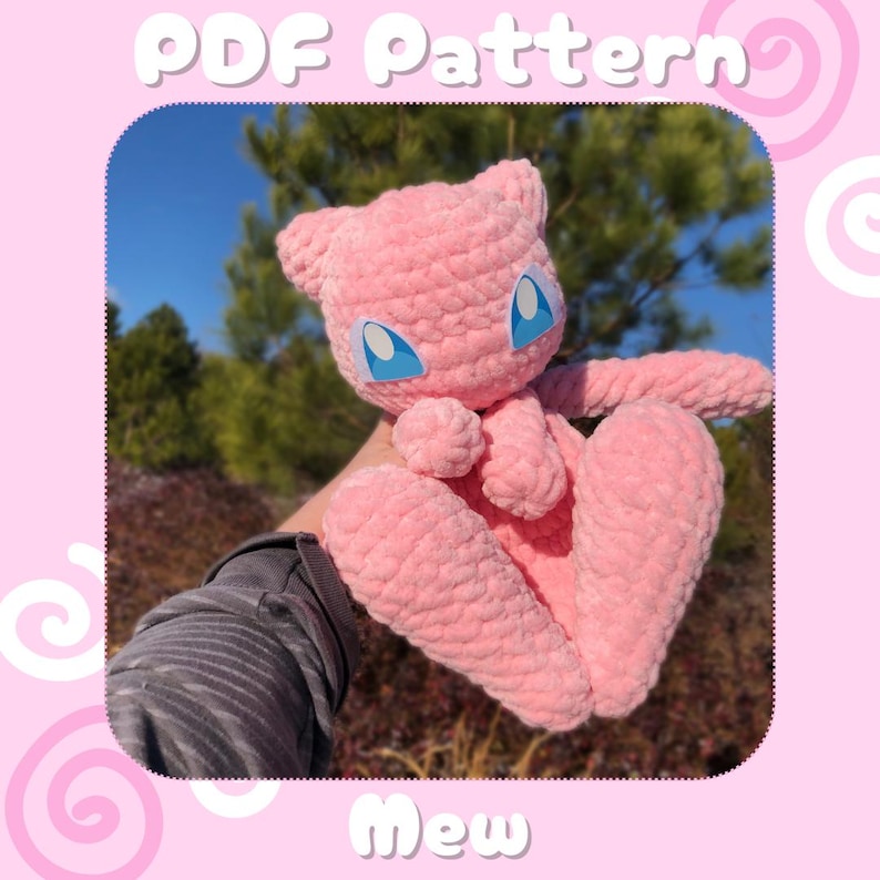 May include: A pink, crocheted Mew plush toy with blue eyes and a small nose. The toy is made of a soft, textured yarn and has a cute, friendly expression. The image includes the text "PDF Pattern" and "Mew".
