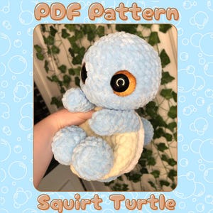 May include: A light blue crocheted squirtle turtle plush toy with a white shell. The toy has large, black eyes with orange pupils.