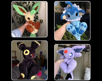 May include: A PDF pattern bundle featuring four crocheted fox-like plush toys in various colors. The toys include a cream and brown fox with green ears, a blue fox, a black fox with yellow accents, and a purple fox.