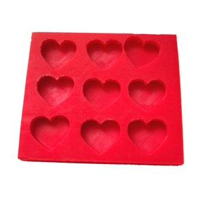 May include: Red silicone mold with nine heart-shaped cavities.