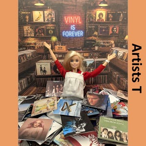 May include: A blonde doll with arms raised, wearing a red long-sleeve shirt and white apron, stands amidst a collection of miniature vinyl record covers. The background features a record store interior with shelves of albums and a neon sign reading VINYL IS FOREVER.