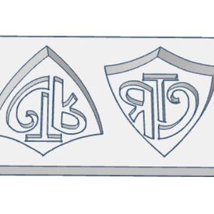 May include: A light gray rectangular mold with two shield-shaped cavities. Each cavity features a stylized monogram design. The left cavity has the letters "GK", and the right cavity has the letters "RT".