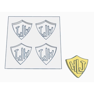 May include: A white silicone mold with four shield-shaped cavities. Each cavity features the letters "LJ" in a stylized font. A separate yellow shield-shaped mold with the letters "HLJ" in a stylized font.