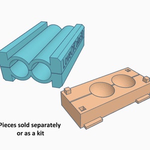 May include: Two light blue plastic molds for making round cookies. The molds are connected together and have the text "LoveOfCookies3D" on the side. The molds are shown next to a light orange plastic mold with two round depressions for making cookies.