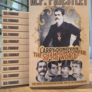 May include: A book titled "Larry Donovan: The Champion Jumper of the World" by M.P. Priestley. The cover features a vintage-style illustration of a man in a suit and a group of men in athletic wear. The text "The Most Outrageous Story You've Never Heard Of" is printed at the bottom.
