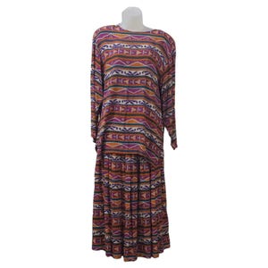 May include: A two-piece outfit with a long-sleeved top and a skirt. The top and skirt are both made of a patterned fabric with orange, purple, and white stripes and geometric designs.