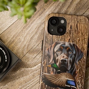 May include: A brown and black Labrador Retriever with a duck in its mouth. The dog is standing in a field of tall grass. The background is a wooden pattern.