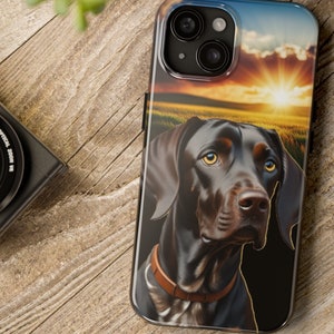 May include: A black and brown dog with a sunset background on a phone case.
