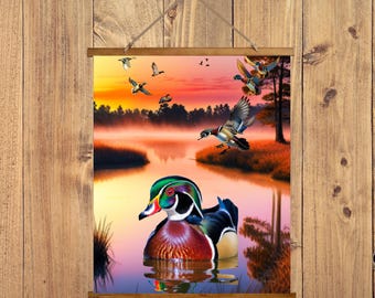 May include: A framed wall art print featuring a vibrant scene of ducks on a lake at sunset. The artwork showcases a colorful wood duck in the foreground, with other ducks in flight against a backdrop of a misty lake and orange sky.