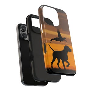 May include: A set of three phone cases. The front case features a silhouette of a dog and a bird against an orange sunset background. The other two cases are black.