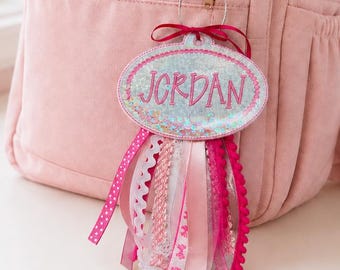 Etiqueta personalizada bordada con purpurina para mochila, con nombre y cintas personalizadas.