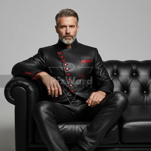 May include: Black leather jacket with red button accents and trim. The jacket features a mandarin collar and is paired with matching leather pants. The outfit is worn while seated on a black leather sofa.
