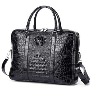 May include: A glossy black briefcase with a crocodile skin texture. The bag has two top handles, a silver zipper, and a detachable shoulder strap. The front features a decorative embossed design.