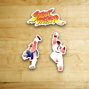 May include: Two Street Fighter characters, Ryu and Ken, are shown in a fighting pose on a wood background. The text "Street Fighter" is shown above the characters.