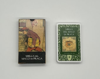May include: Two cards from the Sibilla del Mago di Praga tarot deck. The card on the left shows a man carrying two boxes. The card on the right shows an eye in a cloud with a green border.