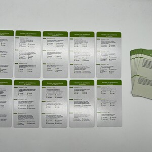 Peut inclure: Un jeu de 10 cartes argent&eacute;es avec des bordures vertes et du texte en noir. Les cartes portent le titre "Scrabble, une question de culture" et contiennent des questions &agrave; choix multiples. Les cartes sont dispos&eacute;es en deux rang&eacute;es de cinq.