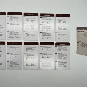 Peut inclure: Un jeu de 16 cartes avec le mot "Personnalit&eacute;s" imprim&eacute; en haut de chaque carte. Chaque carte contient une question et des r&eacute;ponses &agrave; choix multiples. Les cartes sont dispos&eacute;es sur une surface blanche.