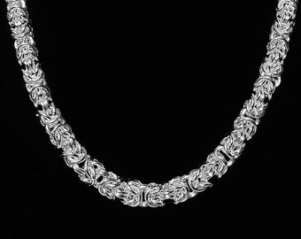 May include: A silver chain necklace with a byzantine style design.