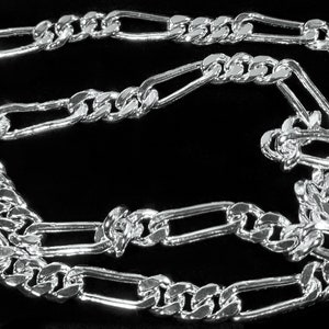 May include: A silver Figaro chain necklace with a box chain design. The chain is made of interlocking oval and round links.