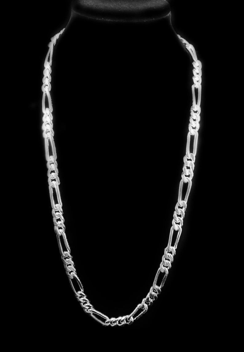 May include: A silver chain necklace with a figaro link pattern.
