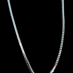 May include: A silver chain necklace with a herringbone pattern.