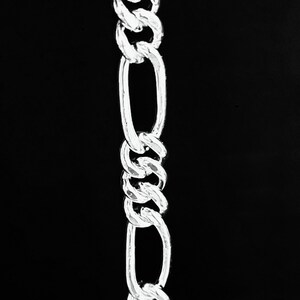 May include: A silver chain with a twisted design. The chain is made of oval links and is about 10 inches long.