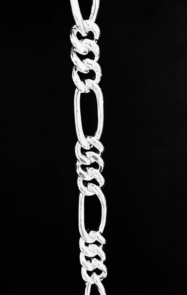 May include: A silver chain with a twisted design. The chain is made of oval links and is about 10 inches long.