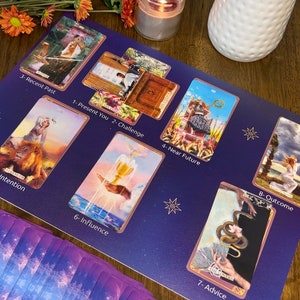May include: A tarot card spread with ten cards laid out on a purple background. The cards are labeled with numbers and titles, including "Recent Past", "Present You", "Challenge", "Near Future", "Outcome", "Intention", "Influence", and "Advice".