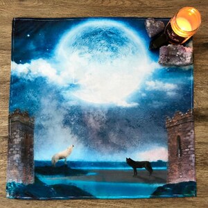 May include: A blue and white tapestry with a full moon, clouds, and two wolves howling at the moon. The tapestry has two stone towers on either side.