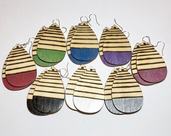 May include: Ten pairs of wooden teardrop-shaped earrings with striped patterns. Each earring has a different colored bottom half, including red, green, blue, purple, black, and silver.