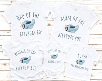 May include: Set of five white t-shirts with blue airplane graphics and text. The shirts say "Dad of the Birthday Boy", "Mom of the Birthday Boy", "Brother of the Birthday Boy", "Sister of the Birthday Boy", and "Adam the Birthday Boy".