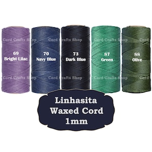 Può includere: Sei bobine di cordoncino cerato da 1 mm in vari colori: lilla brillante, blu navy, blu scuro, verde e oliva. Le bobine sono etichettate con il loro colore e numero corrispondenti. Il testo "Linhasita Waxed Cord 1mm" è stampato sotto le bobine.