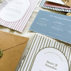 May include: Wedding invitation suite with a striped design in pink and green. The invitation features the names "Daniel & Emmeline" and the date "Saturday, June Fourteen Two Thousand Twenty Three O'Clock in the".
