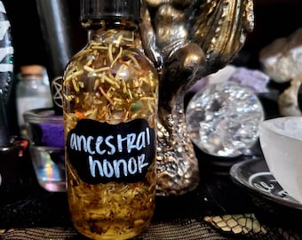 May include: A clear glass bottle with a black label that reads "ancestral honor". The bottle is filled with a yellow liquid and dried herbs. The bottle is sitting on a black surface.